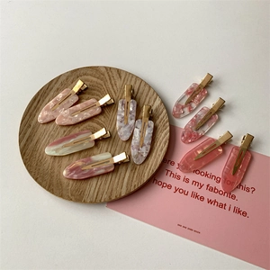 Pink and white marble texture acetate hair clips set with gold duckbill fasteners