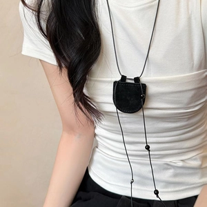 Detail of minimalist black faux leather magnetic glasses holder necklace with bead accents
