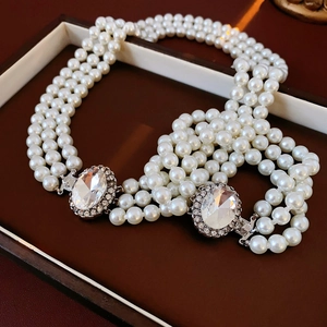 Dettaglio del bracciale di perle a più fili con fermagli ovali in strass in astuccio