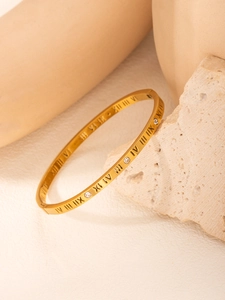 Macro detail of 18k gold plated bangle with Roman numerals and sparkling crystals