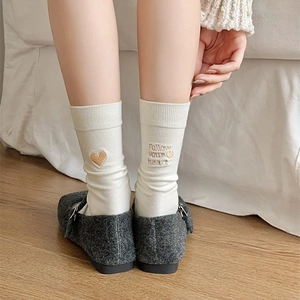 Detailed embroidery of heart and FOLLOW your heart text on cream cotton crew socks