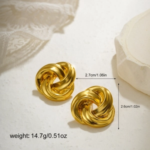 Close-up of golden twist earrings with spiral metal design and glossy finish
