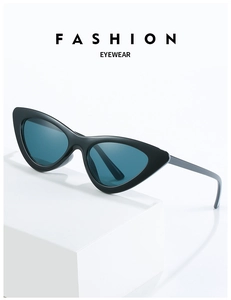 Detail of black cat-eye sunglasses with dark teal lenses on a white minimalist display
