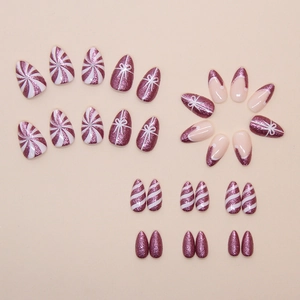 Sparkly purple almond press-on nails with white glitter stripes and bow design