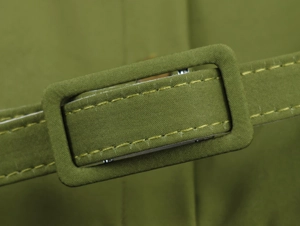 Close-up of green fabric belt buckle with detailed stitching on a floral midi dress