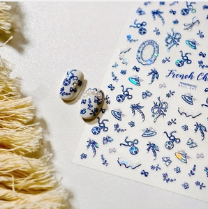 Macro detail of blue and white French Chic floral nail stickers with lace and pearl accents