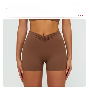Detail view of high-waist brown yoga shorts with V-cross waist and scrunch butt design