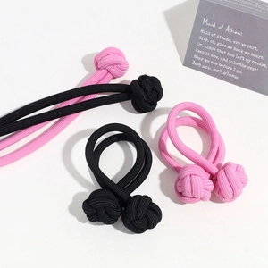 Close-up of pink and black woven flower hair ties with elegant button knot details