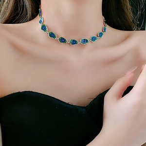 Detail showing teal lotus leaf enamel necklace worn by model in light luxury style