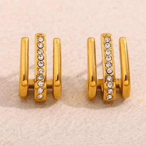 Macro detail of triple-layer J-hook gold earrings with sparkling pave-set crystal rhinestones
