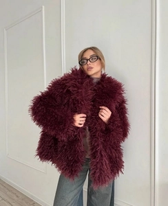 Close-up of fluffy faux fur texture in wine red on a stylish short plush coat