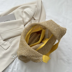 Chic beige woven straw beach bag with yellow handles and spacious interior for travel