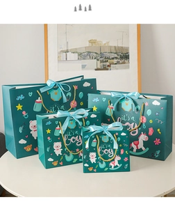 Detailed view of four dark green gift bags with gold handles and 'It's a Boy' text