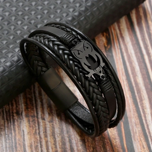Macro detail of men's leather bracelet featuring a black metal owl and magnetic clasp