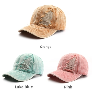 Close-up of distressed vintage baseball caps in orange, blue, and pink colors