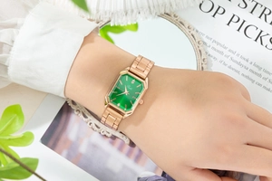Close-up of women's square quartz watch with green dial and rose gold steel strap