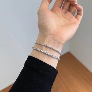 Close-up of double-layered silver tennis bracelets with cubic zirconia on female wrist