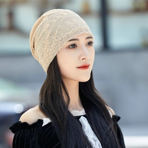 Detailed view of beige lace beanie with sparkling rhinestones on an outdoor model