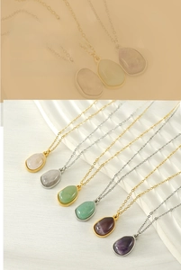 Close-up of irregular natural stone pendant necklaces on a white decorative tray