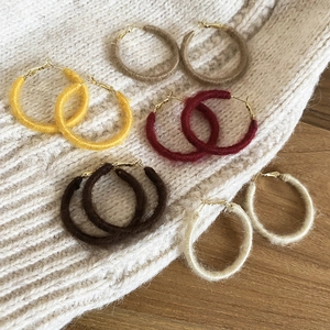 Detail of five multi-colored wool wrapped hoop earrings for autumn and winter collection