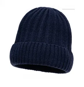 Detailed texture of navy blue knit beanie with ribbed pattern and leather label