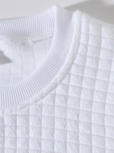 Detailed view of white quilted sweatshirt fabric with a ribbed crew neck and grid pattern