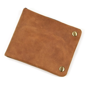 Detailed close-up of brown genuine leather wallet with brass studs and vintage texture