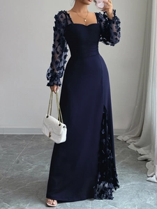 Détail d'une élégante robe de soirée bleu foncé avec manches fleuries et fente haute