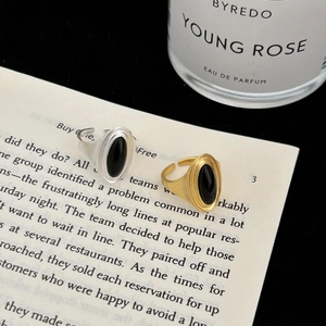Detail of vintage adjustable silver and gold rings with black onyx on an open book