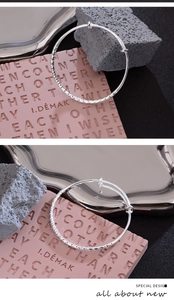 Detail view of silver hammered texture bangle with minimalist geometric diamond-cut finish