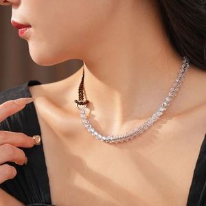 Close-up of faceted crystal bead necklace with brown woven cord on model