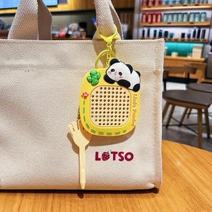 Portachiavi con lavagna magnetica panda appeso a borsa beige in un bar accogliente