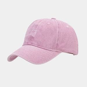 Detail of pink washed cotton baseball cap with white embroidered dog graphic on the front