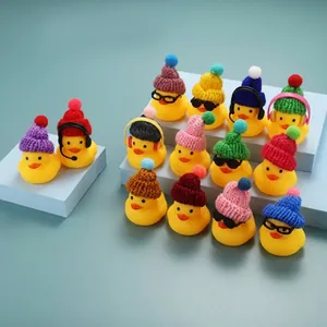 Gros plan de canards jaunes portant des mini bonnets tricotés et des lunettes