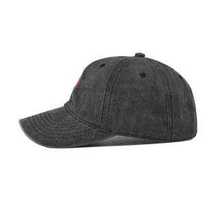 Side view of washed denim baseball cap featuring red embroidery and vintage texture