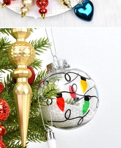 Detail of colorful gourd and icicle Christmas ornaments hanging on a festive tree branch
