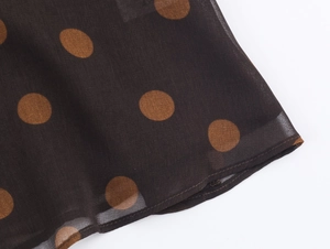 Detailed close-up of brown polka dot chiffon fabric showing texture and stitching