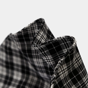 Macro shot of black and white plaid fabric texture with precise overlock stitching detail