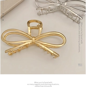 Close-up of gold and silver metal bow hair claws with hollowed-out double line design