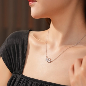 Détail d'un collier argenté élégant avec pendentif fleur en zircone sur le cou du modèle