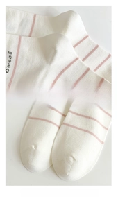 Detail of seamless heel and reinforced toe on white striped cotton socks with Sweet text