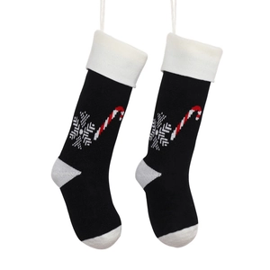 Pair of black knitted Christmas stockings with white snowflake and candy cane patterns