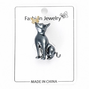 Detail of dark gray alloy cat brooch with golden butterfly accent on white card
