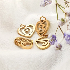 Close-up of golden stainless steel heart charms with hollow number design for DIY jewelry