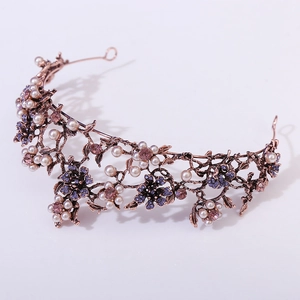 Detail of baroque bridal crown with purple crystals and pearls on vintage copper floral metal