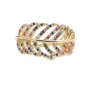 Golden feather ring with colorful cubic zirconia pavé stones on a clean white background