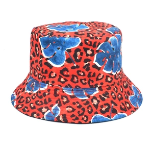 Detail of red bucket hat with black leopard spots and blue tropical leaf print