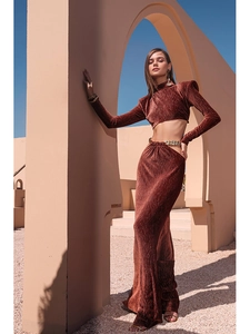Detail of reddish-brown pleated two-piece set with waist chain and side cutout