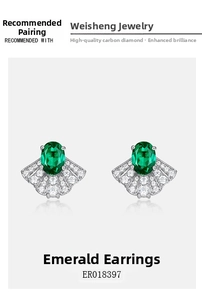 Macro view of emerald stud earrings with vintage fan shaped diamond detailing