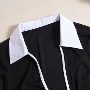 Détail du col blanc contrasté et de la maille côtelée noire sur le body à manches longues